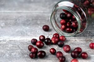 Jar and cranberries. Selective focus on cranberries and jar sides. Close up